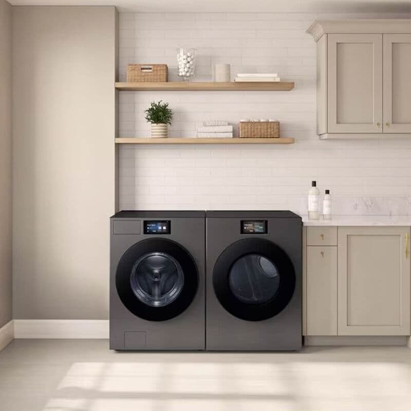 samsung washer and dryer in silver in a laundry room with white cabinets