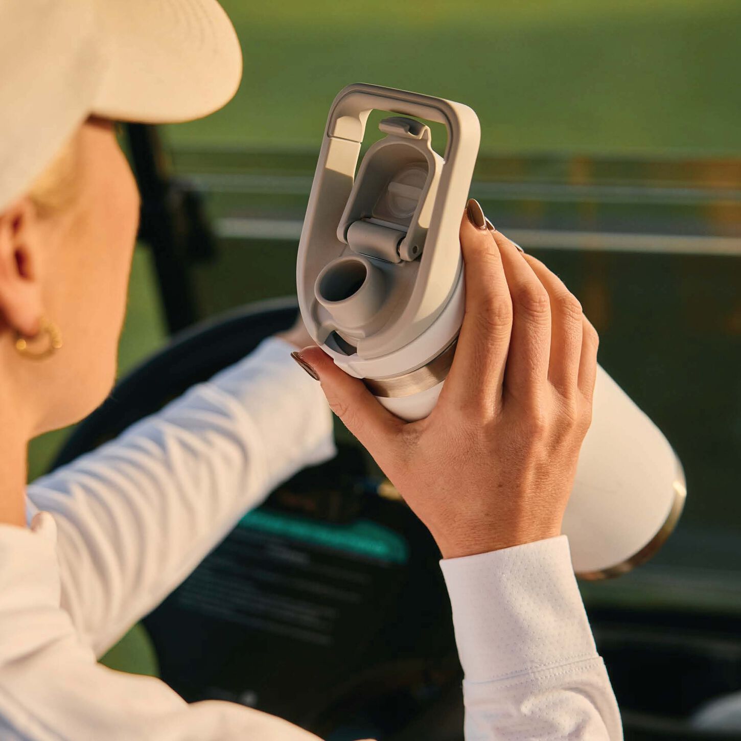lady in a baseball cap drinking out of a yeti water bottle