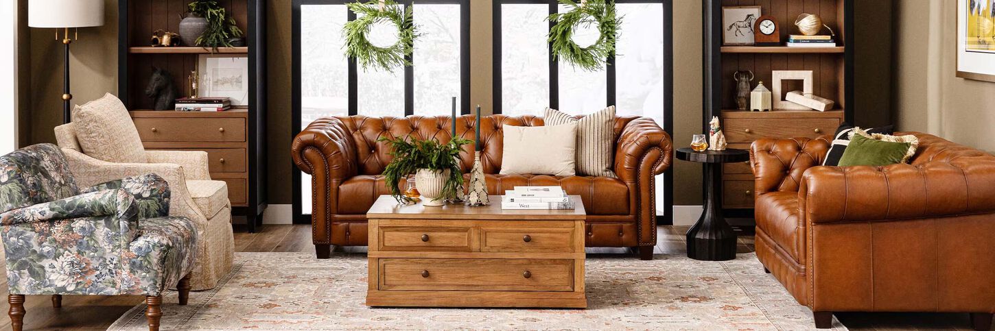Holiday-decorated living room featuring brown leather sofas