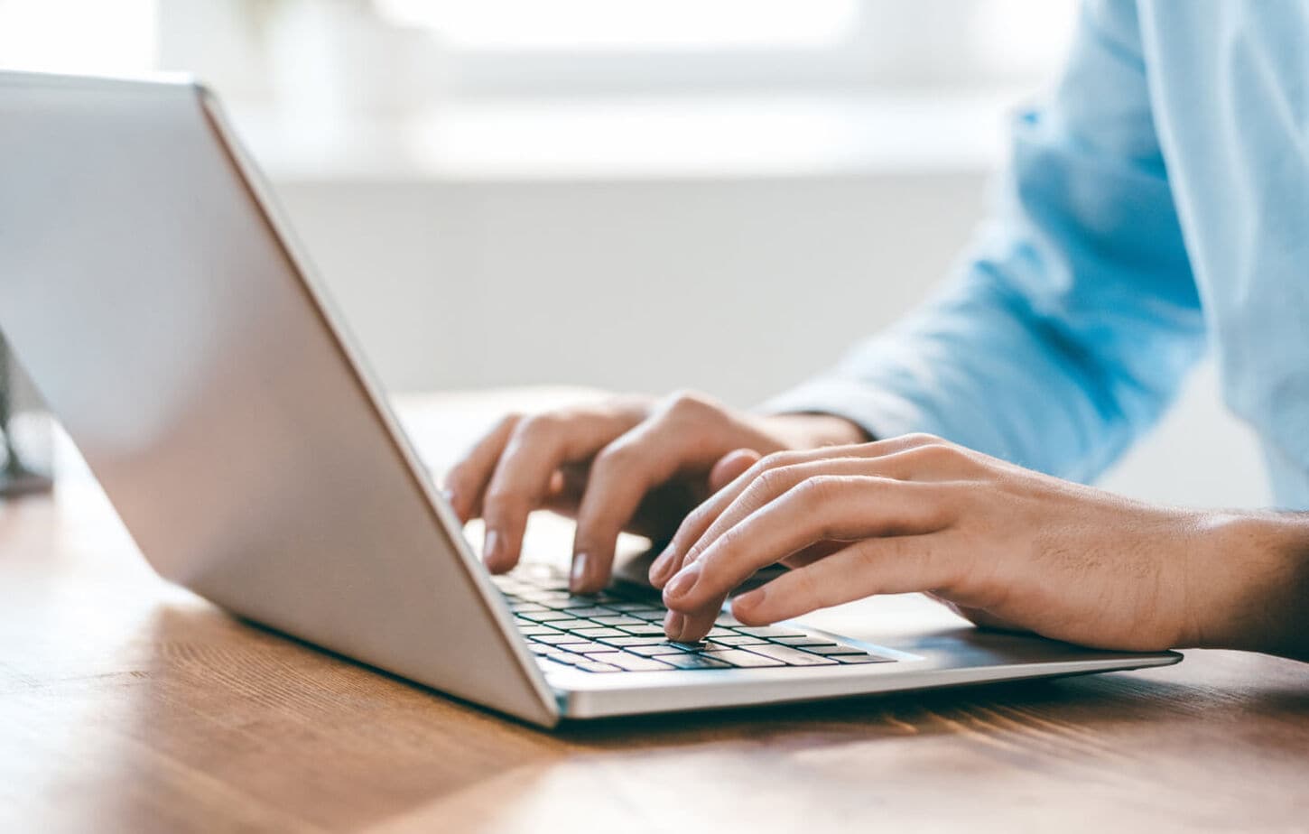 A person typing out a message on their laptop