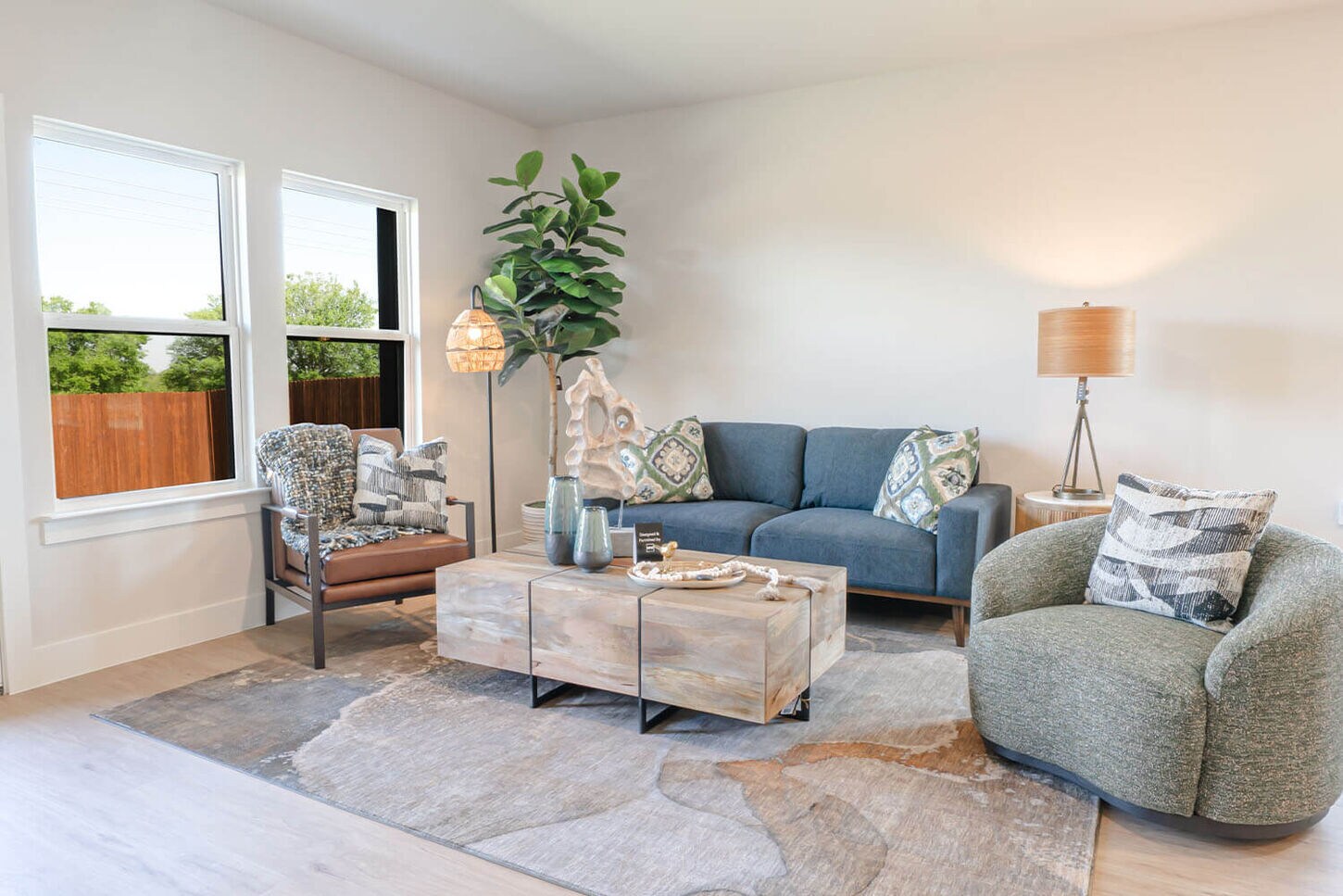 Living room with a sofa, two chairs, a large rug, and coffee table.