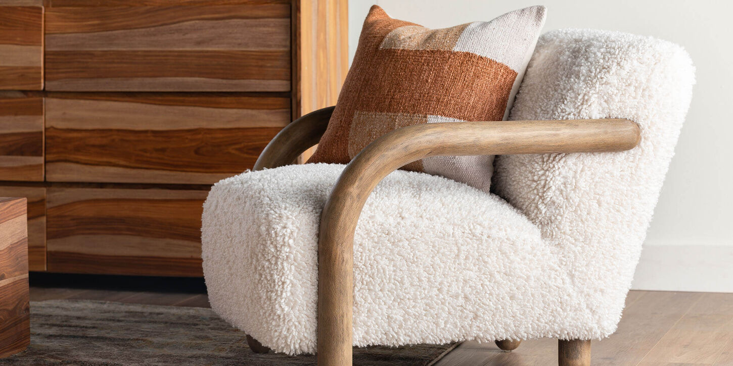 Wool chair with brown stripe throw pillow with a brown dresser in background.