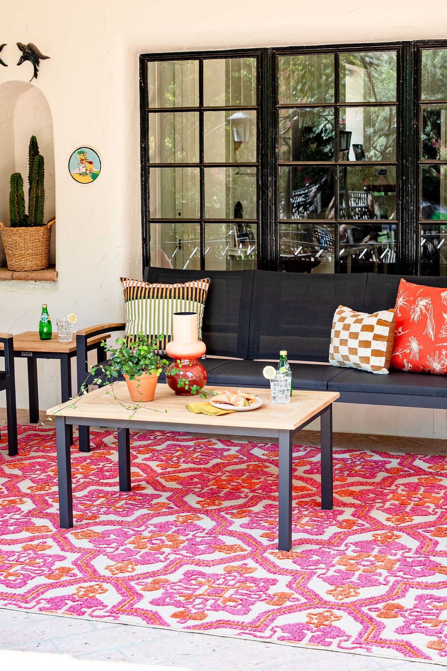 Outdoor furniture on a patio with a rug, table, and bench