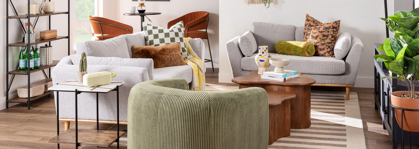 Brightly lit living room with gray sofa and green accent chair