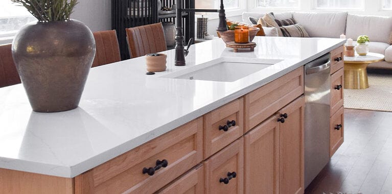 Countertop in kitchen with dark bronze faucet next to living space