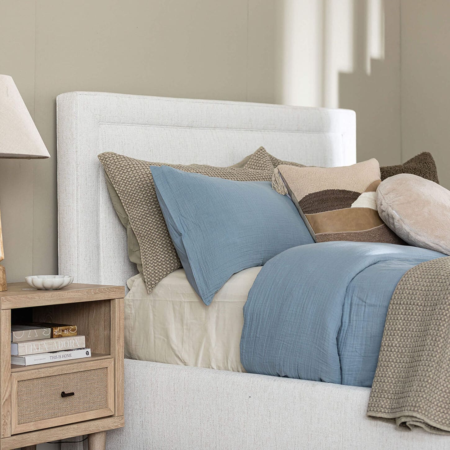 White Upholstered Bed with Blue and Brown Bedding