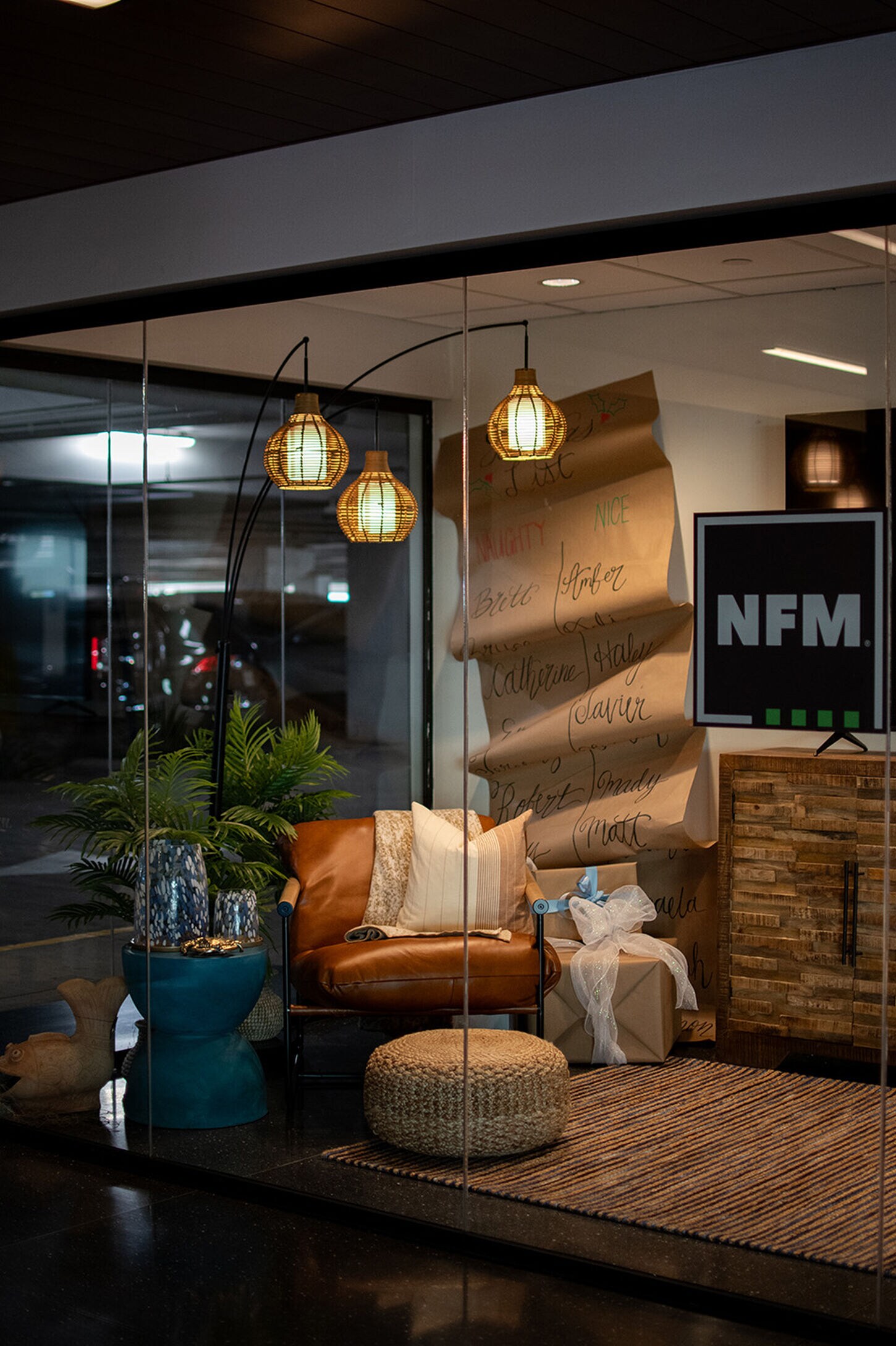 Jewel box at Grandscape fully decorated with NFM furniture including a TV, chair, plant, and holiday naughty and nice list.