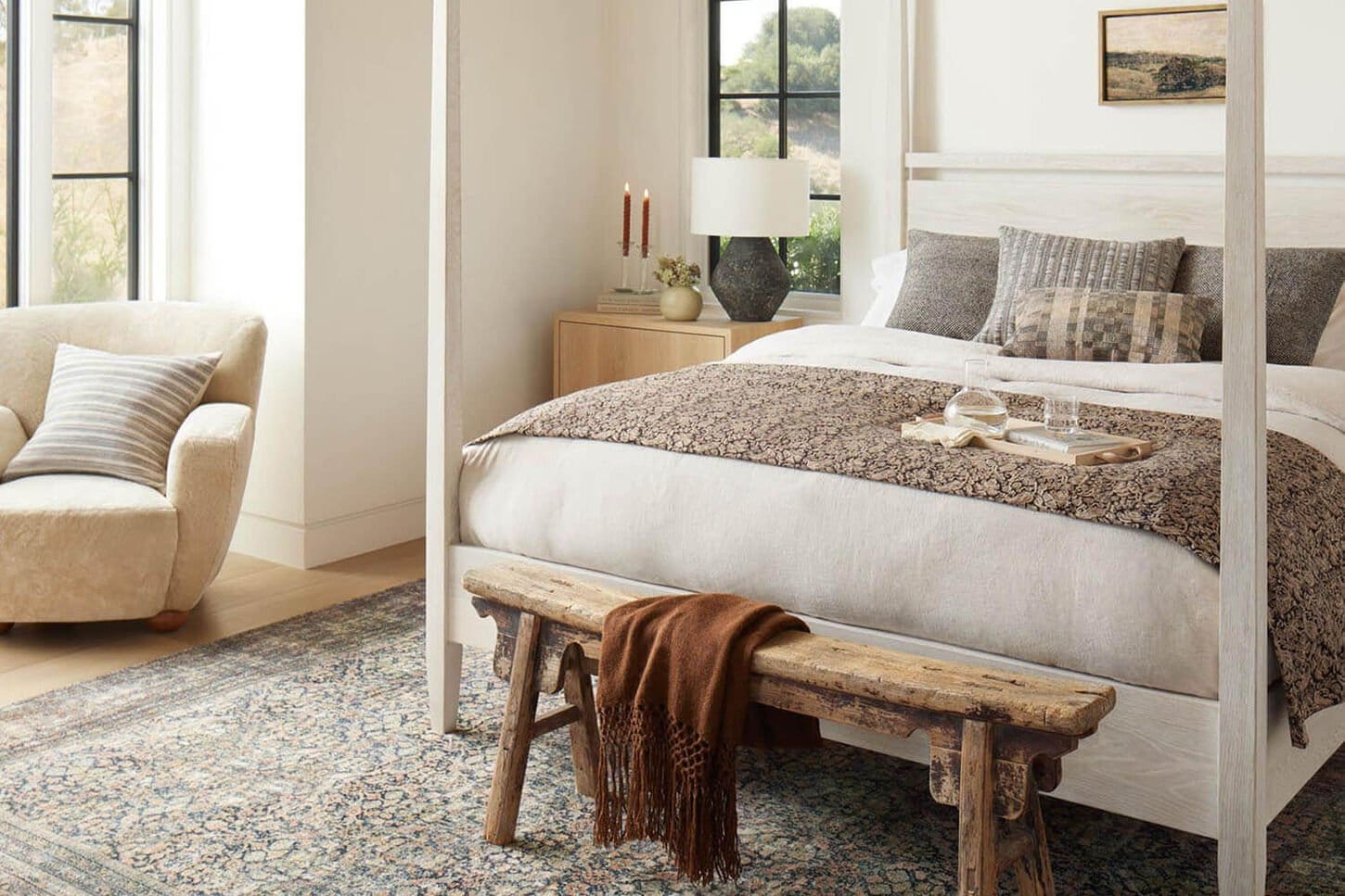 Fall vibe bedding featuring darker shades and more blankets in our Influencer's room with a lamp on the in background