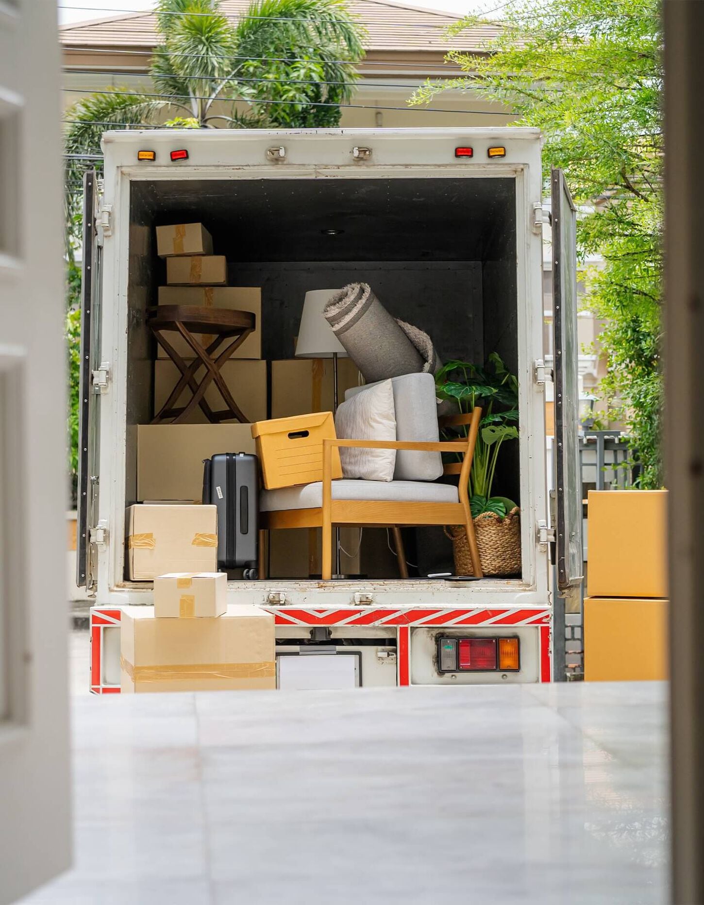 Moving truck full of boxes and furniture outside of a home