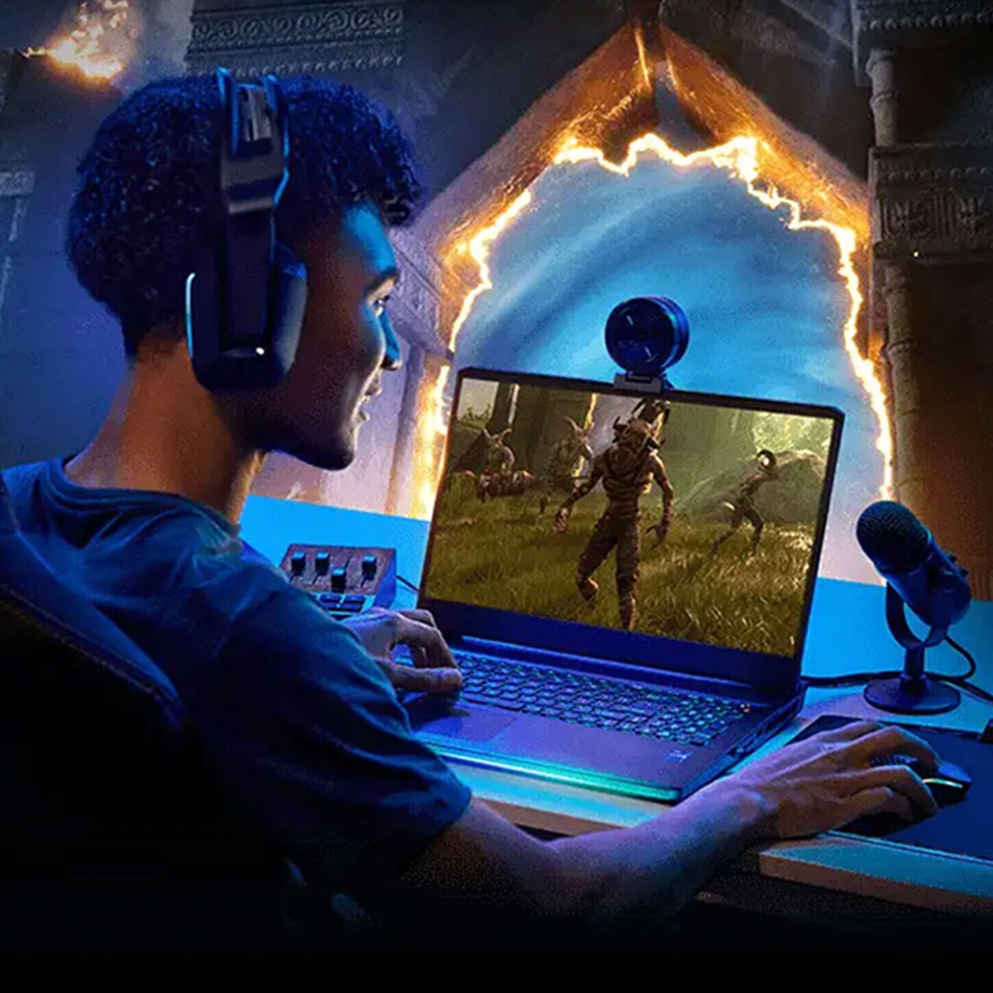 Guy gaming on his laptop with a microphone and fun light setup