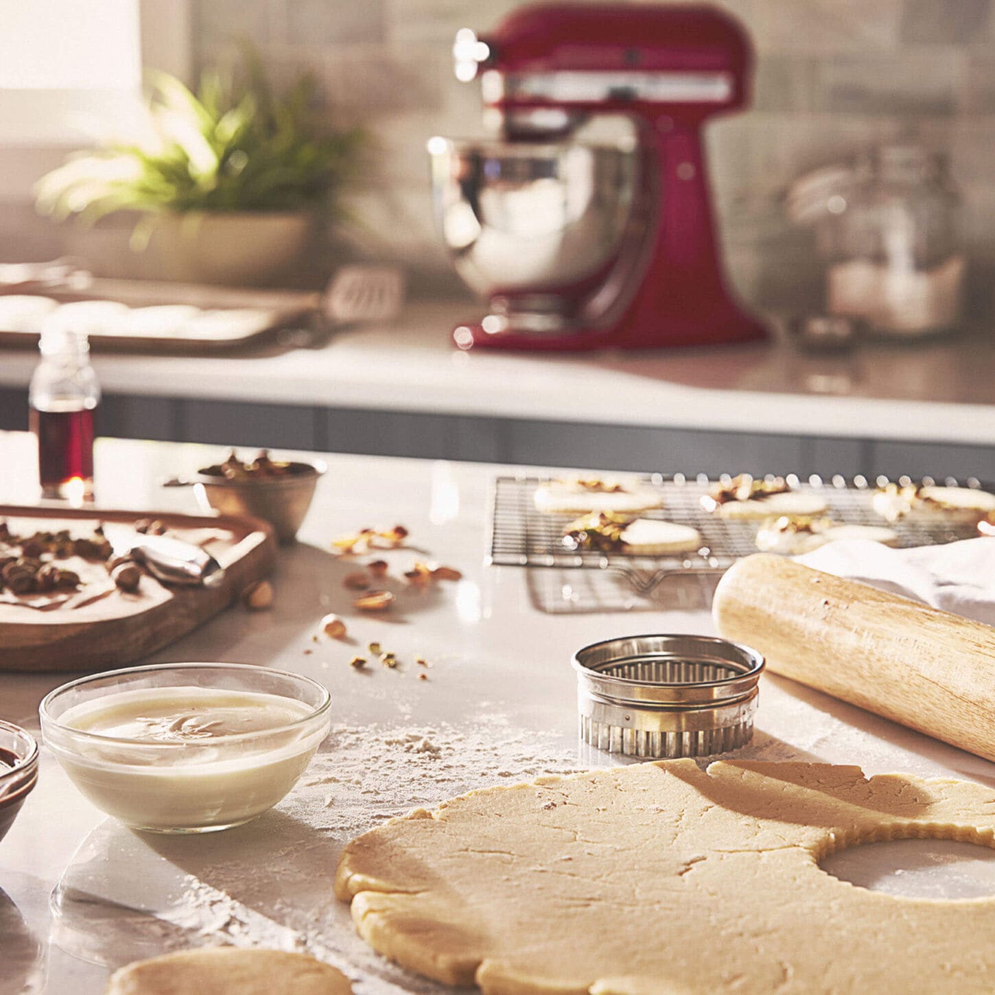 Messy kitchen baking cookies with a kitchen aid mixer in the background