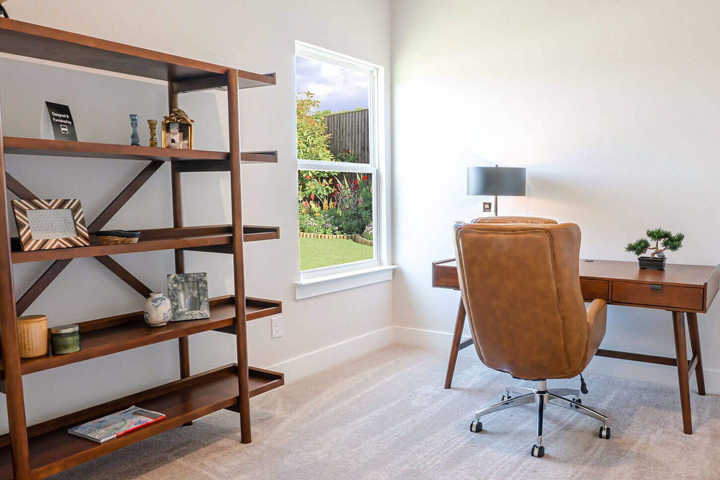 An office with a wooden desk and two tan chairs.