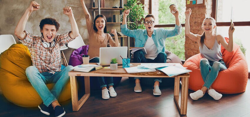 Group of College Students in their Dorm Room Enjoying a Game