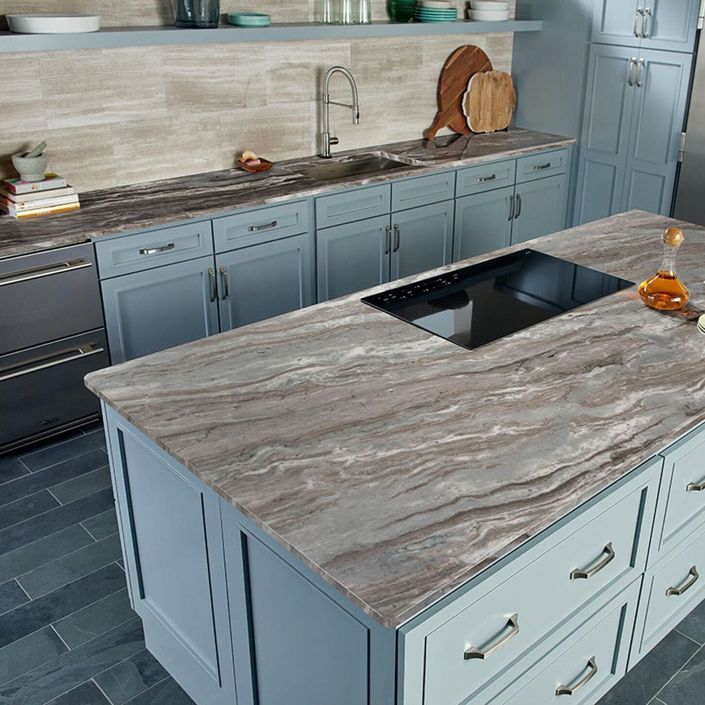 Kitchen with off white cabinets, grey and black marble countertops, and a grey tiled floor