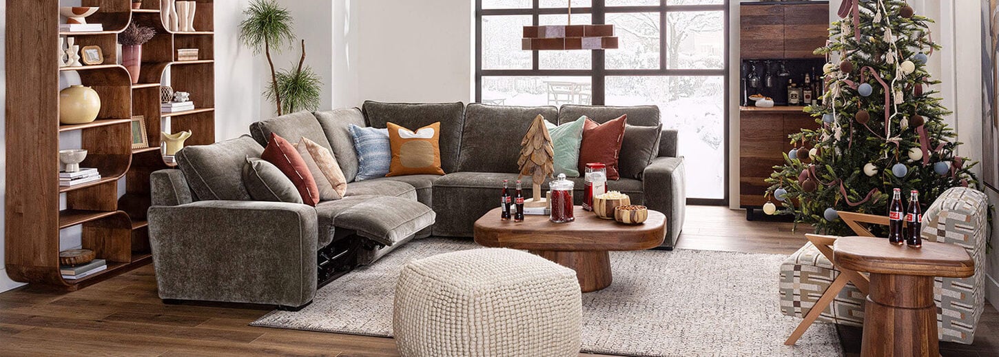 Living room with large sectional, area rug, coffee table, ottoman and various decor