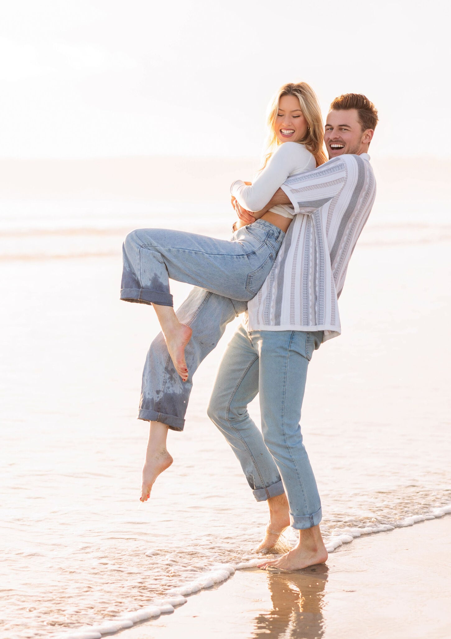 Megan and her husband posing at the beach near the ocean