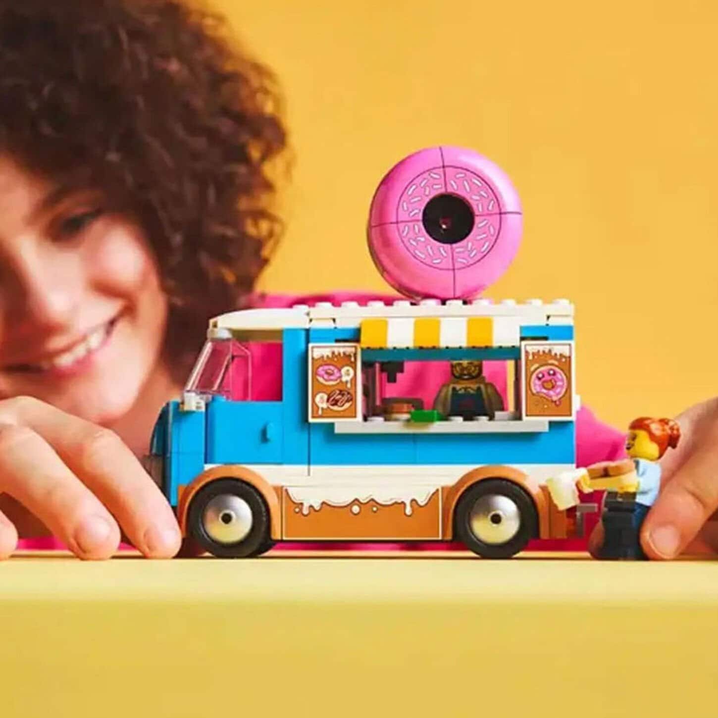 Bedroom with a pillow filled bed alongside a nightstand with a lamp on it