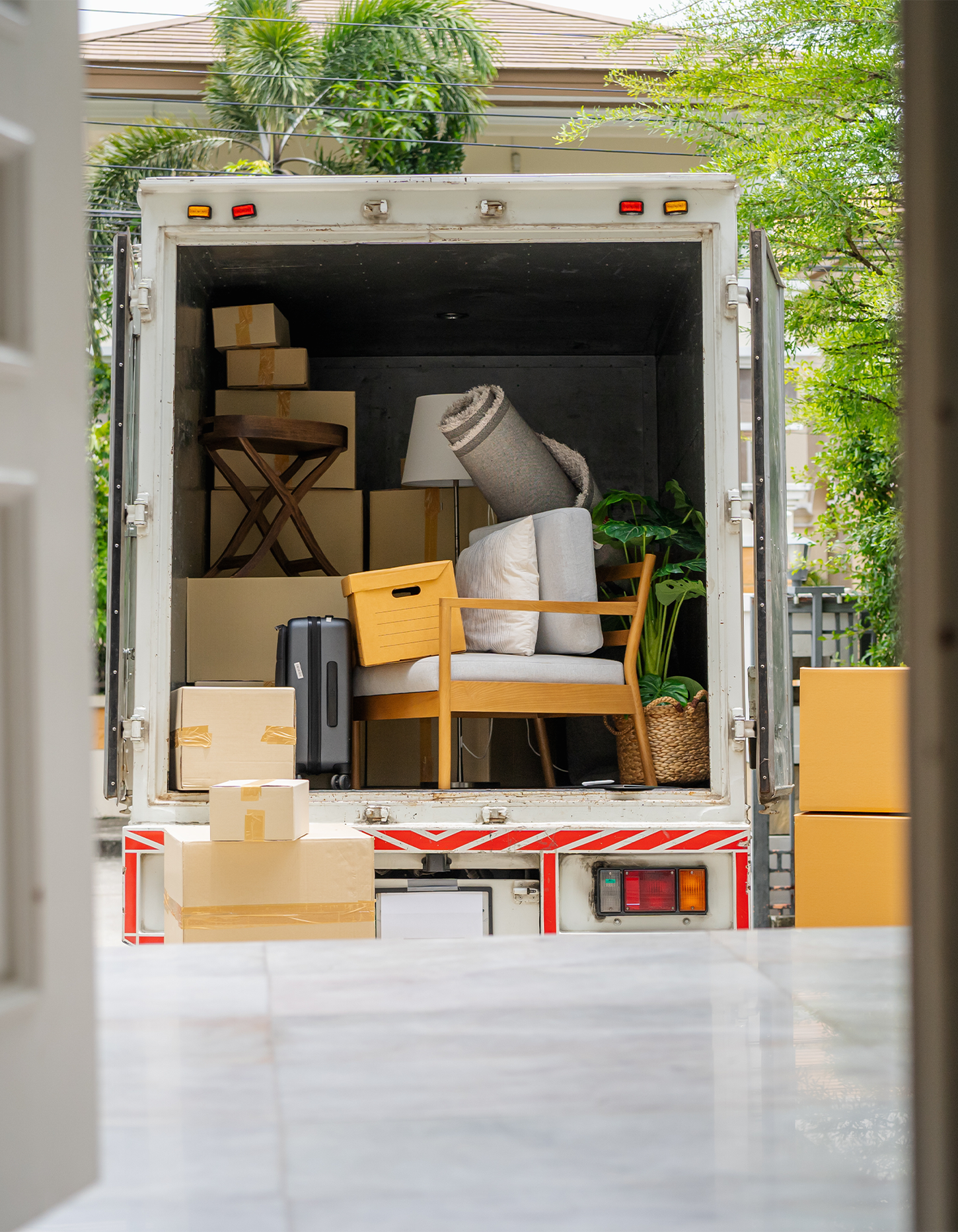 Moving truck full of boxes and furniture outside of a home