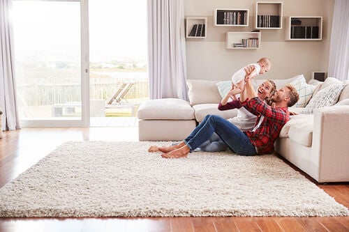 Family playing with baby in living room