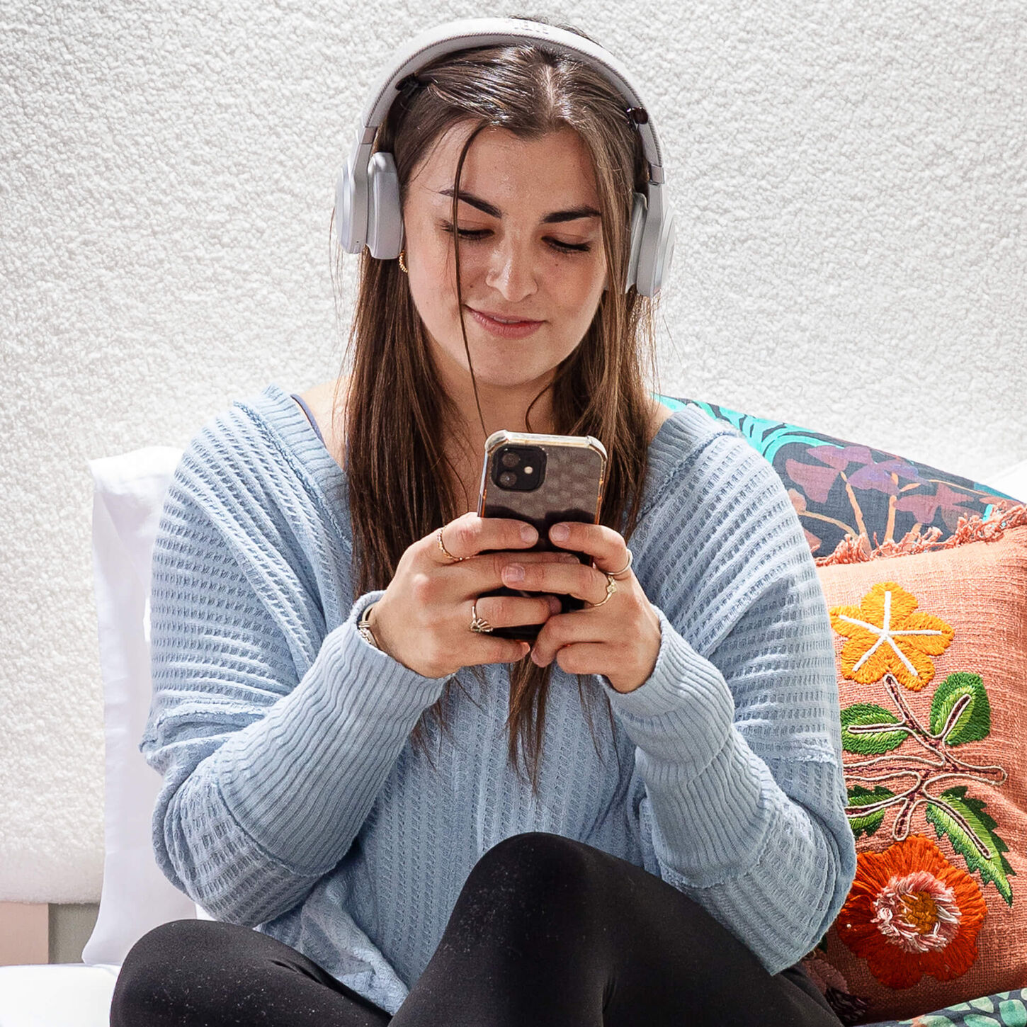 College student using headphones to listen to their phone
