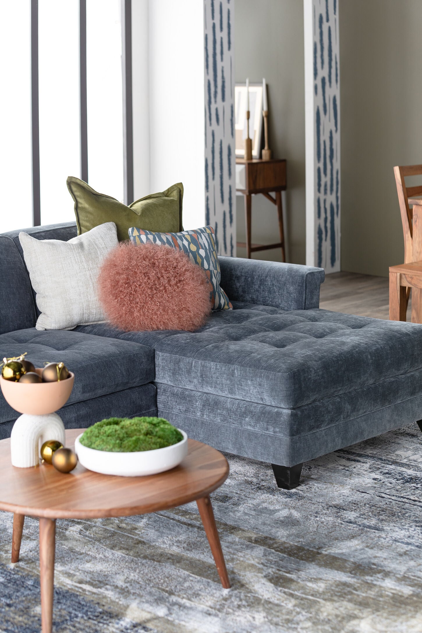 Blue couch in living room with rug and decor