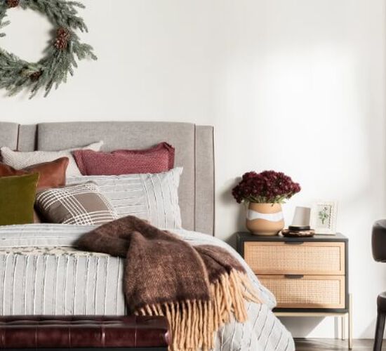 Bedroom with wreath hung above bed and holiday colored decor