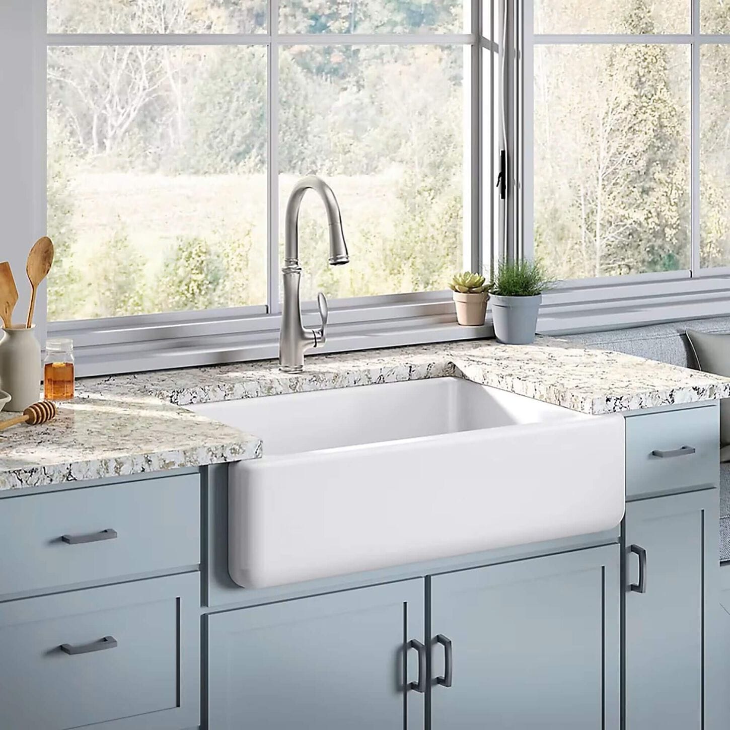kitchen with light blue cabinets a white farm style sink and a brushed aluminum faucet