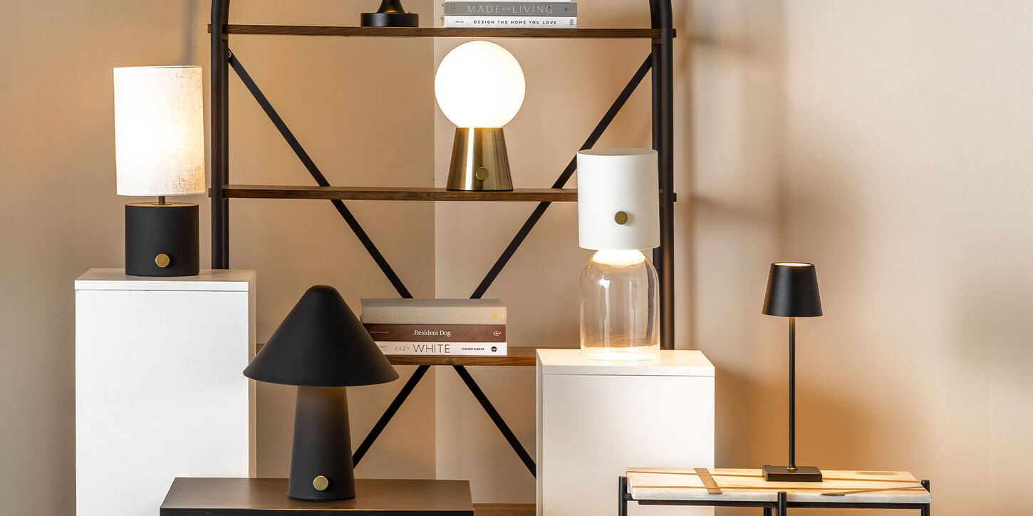 Different lamps displayed on a shelf with books