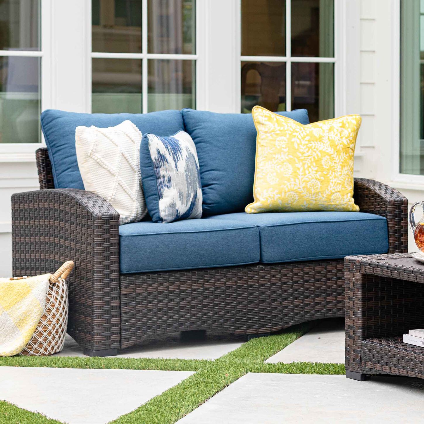 Outdoor loveseat with navy blue cushions in brown