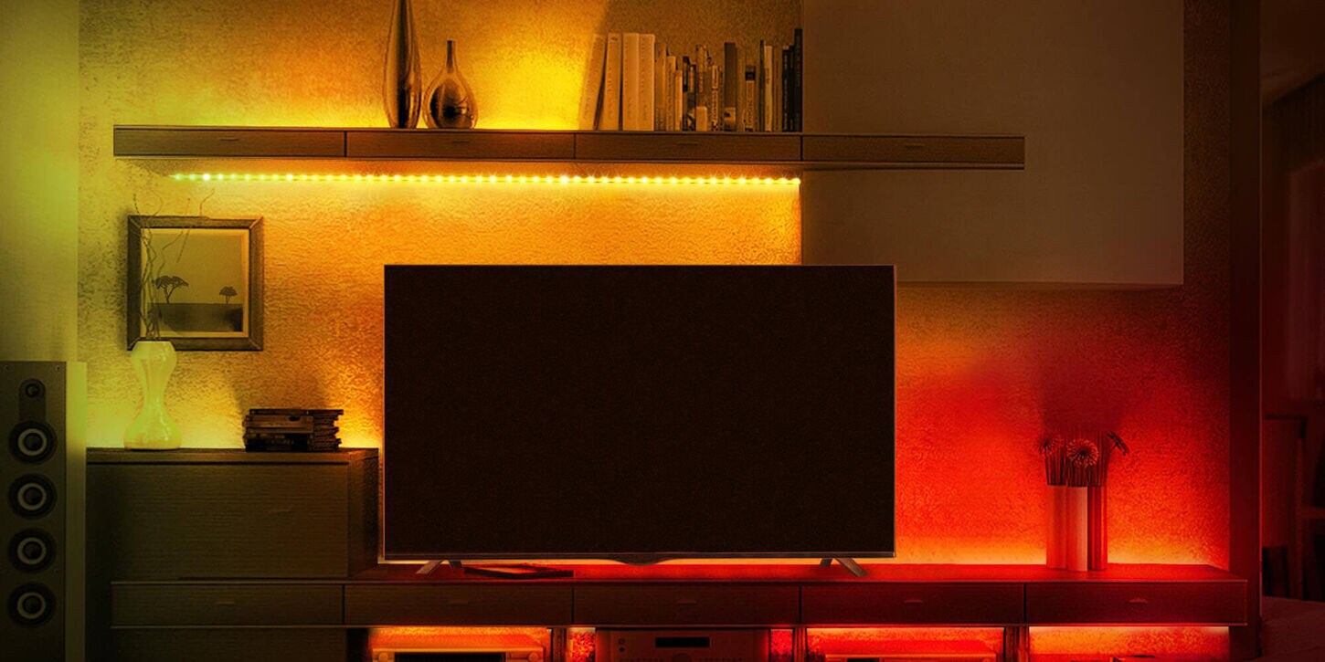 TV in living room with light strips creating a red and yellow background
