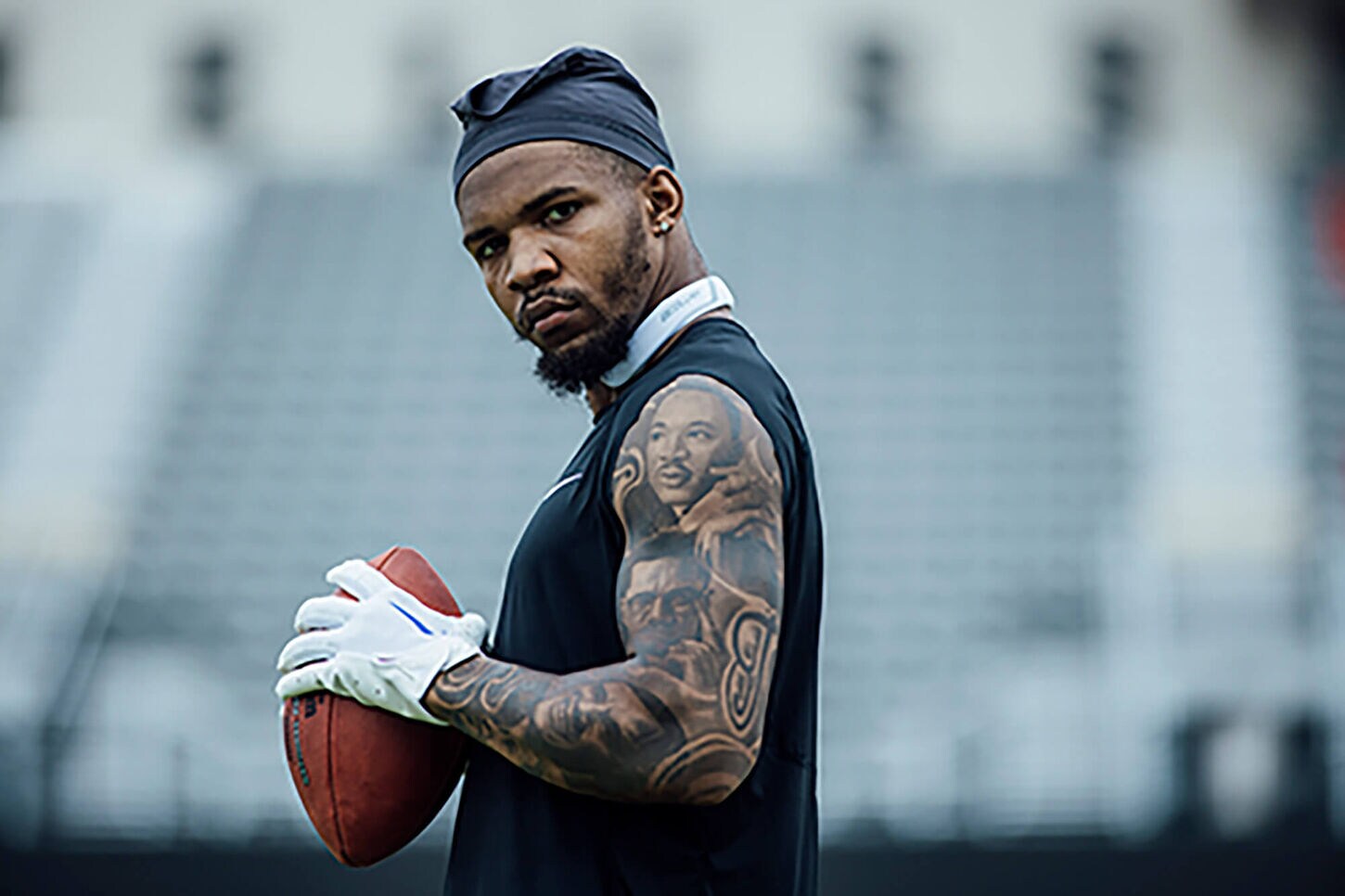 Tony Pollard holding a football looking seriously into the camera.