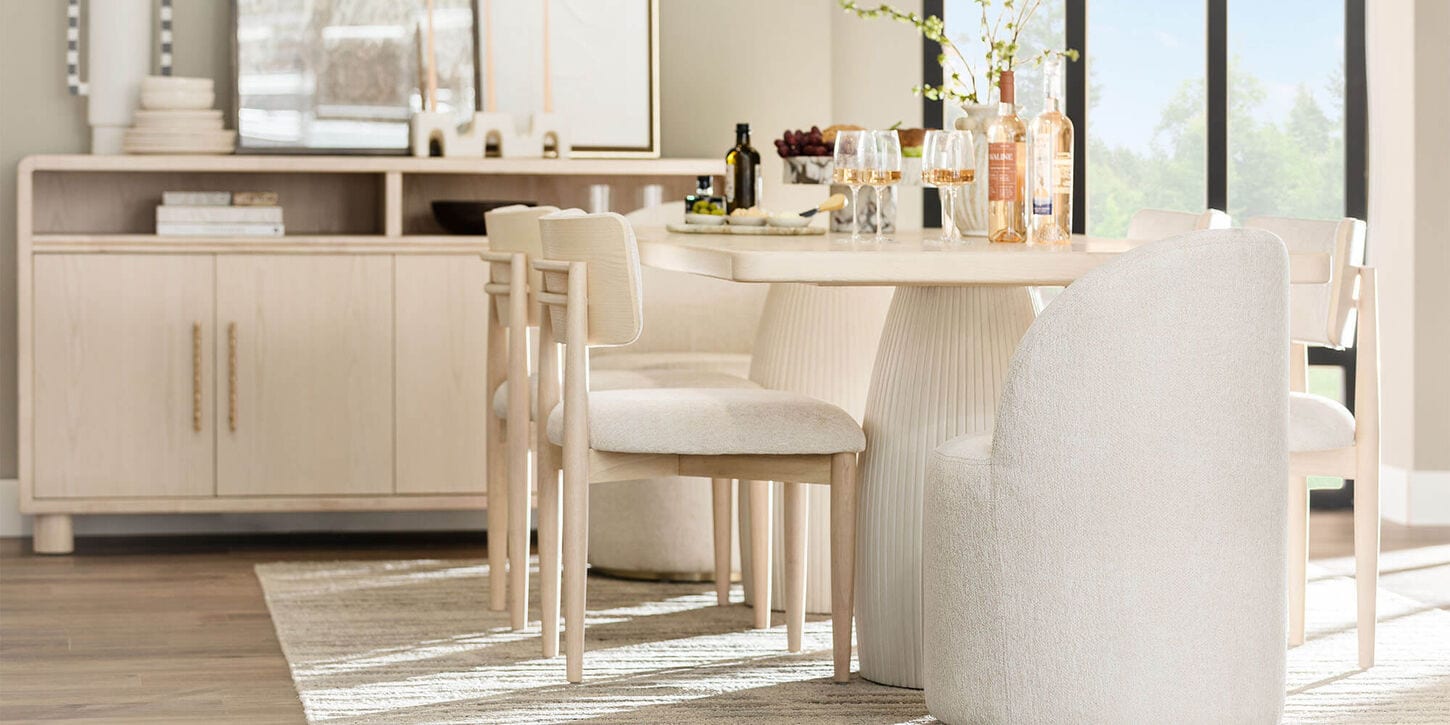 White dining room set with table, chairs, credenza, and decor all in white