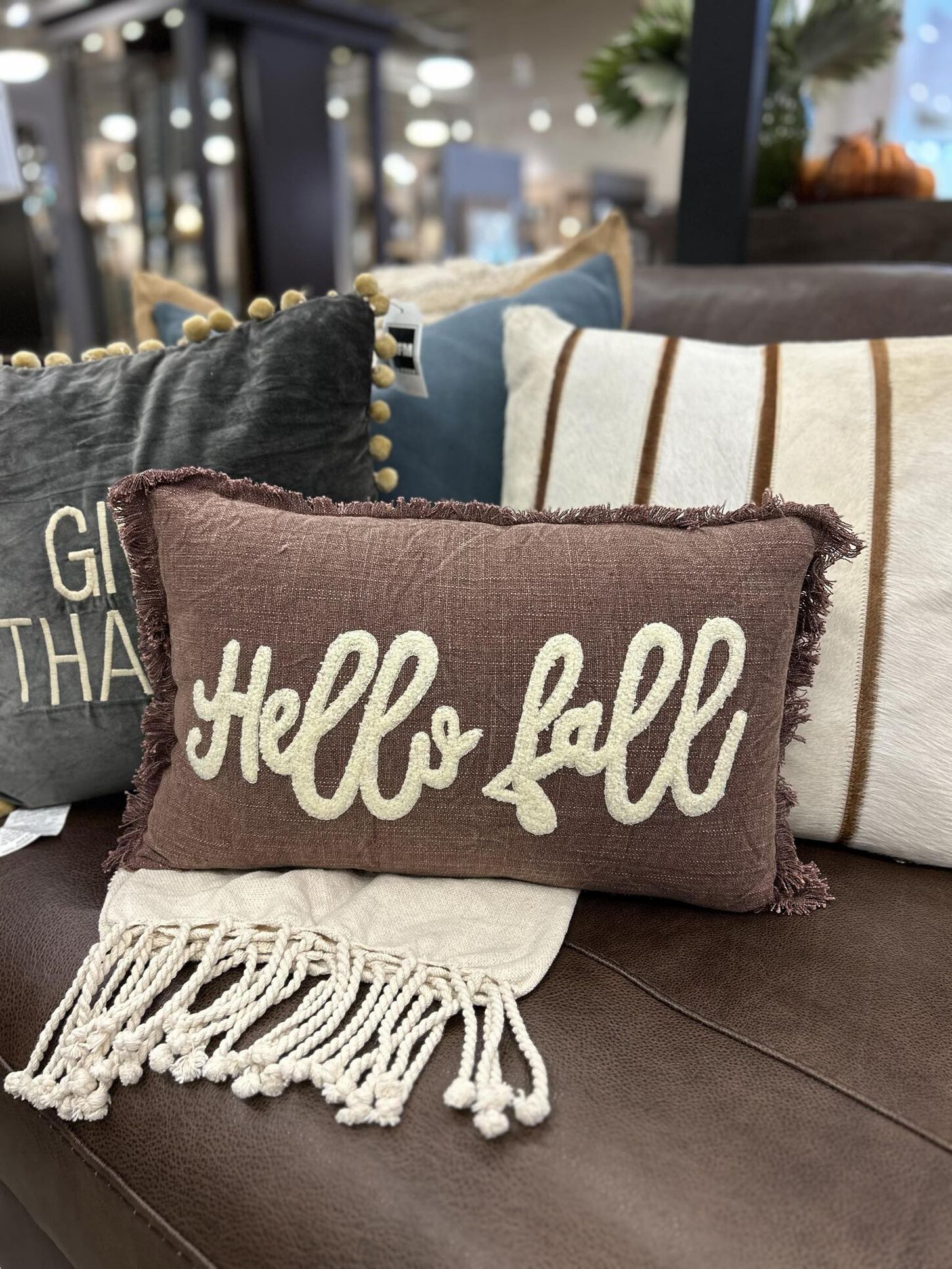 hello fall pillow with other pillows placed on a couch