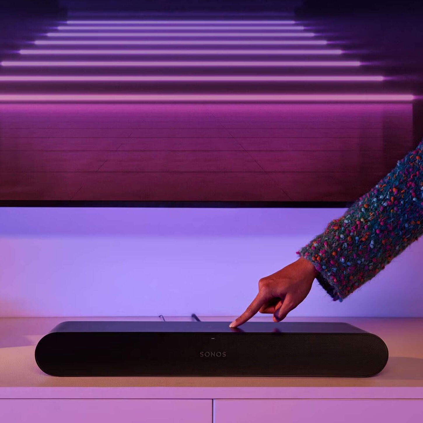 Person clicking button on a soundbar
