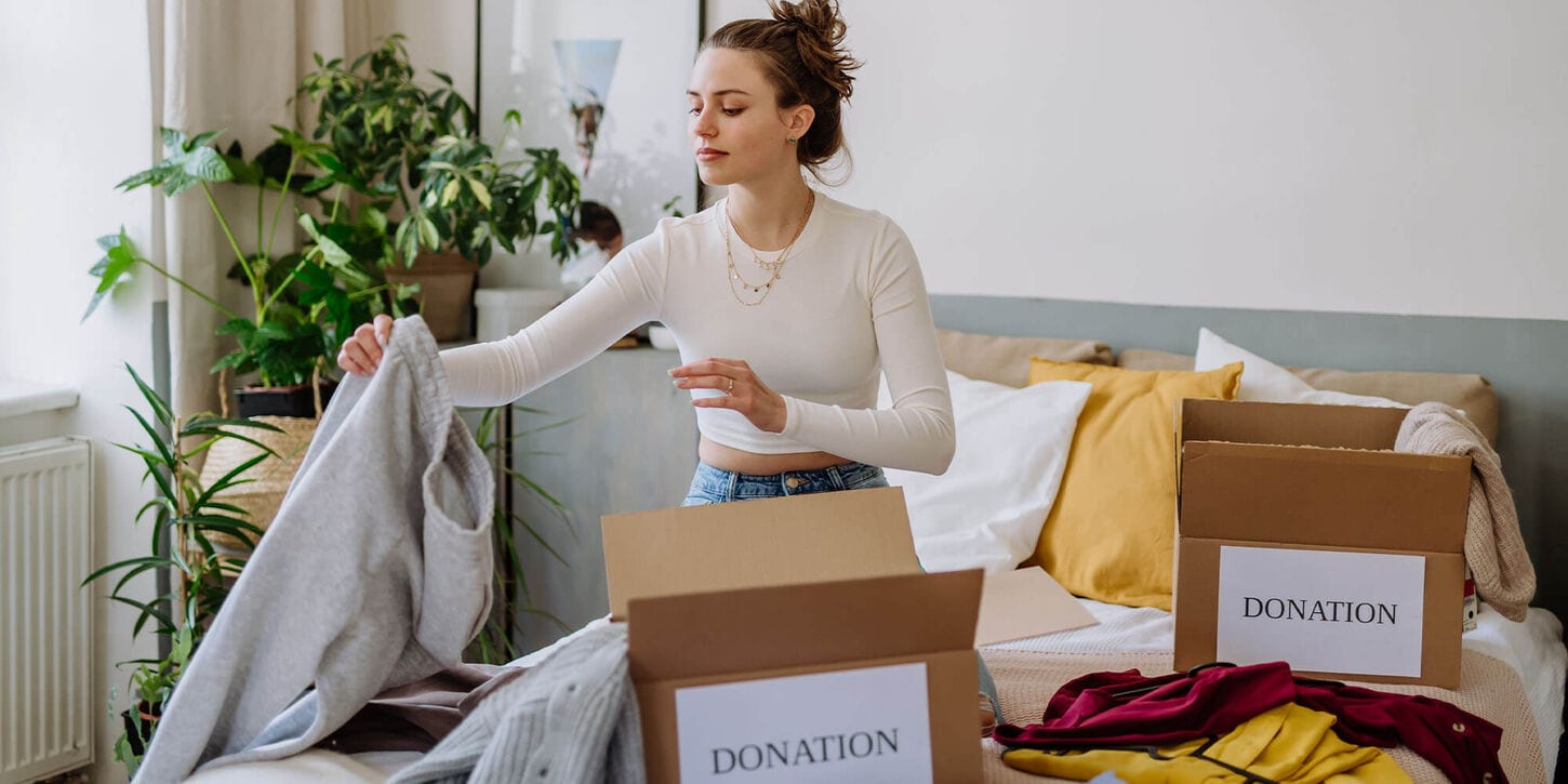 Woman preparing for a move and declutter her home with boxes marked donation