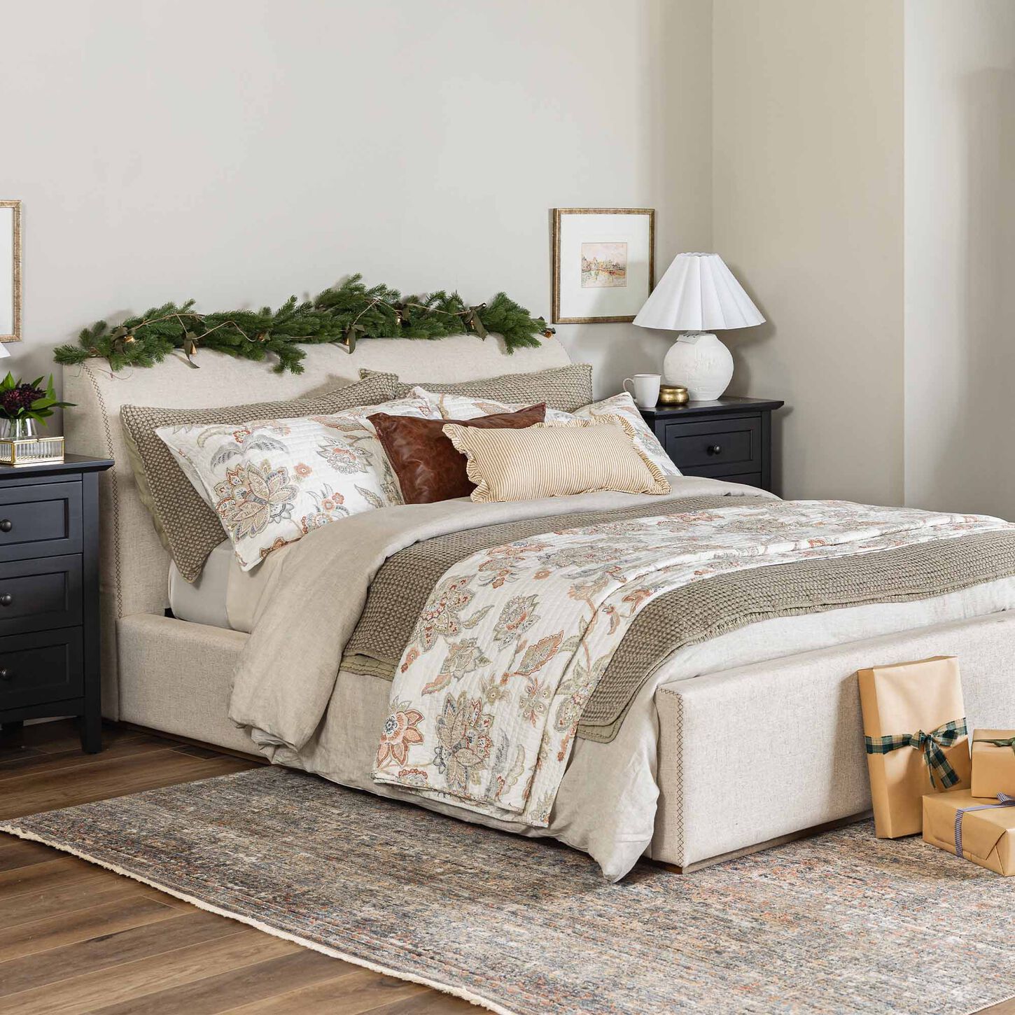 Upholstered bed full of pillows with bird art on the wall