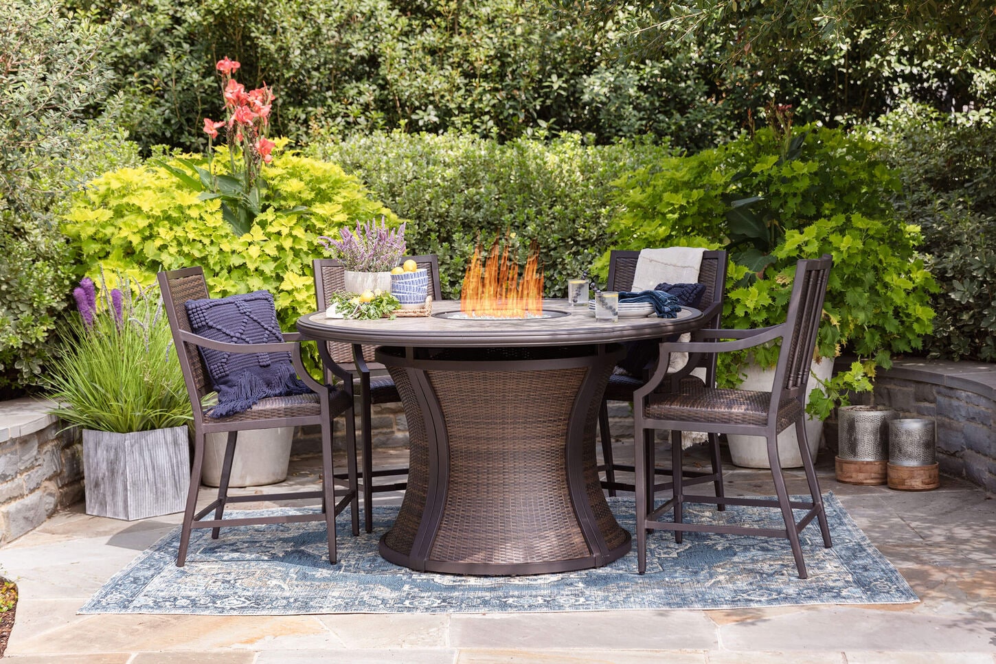 Outdoor firepit dining set on a beautiful day with flowers in background