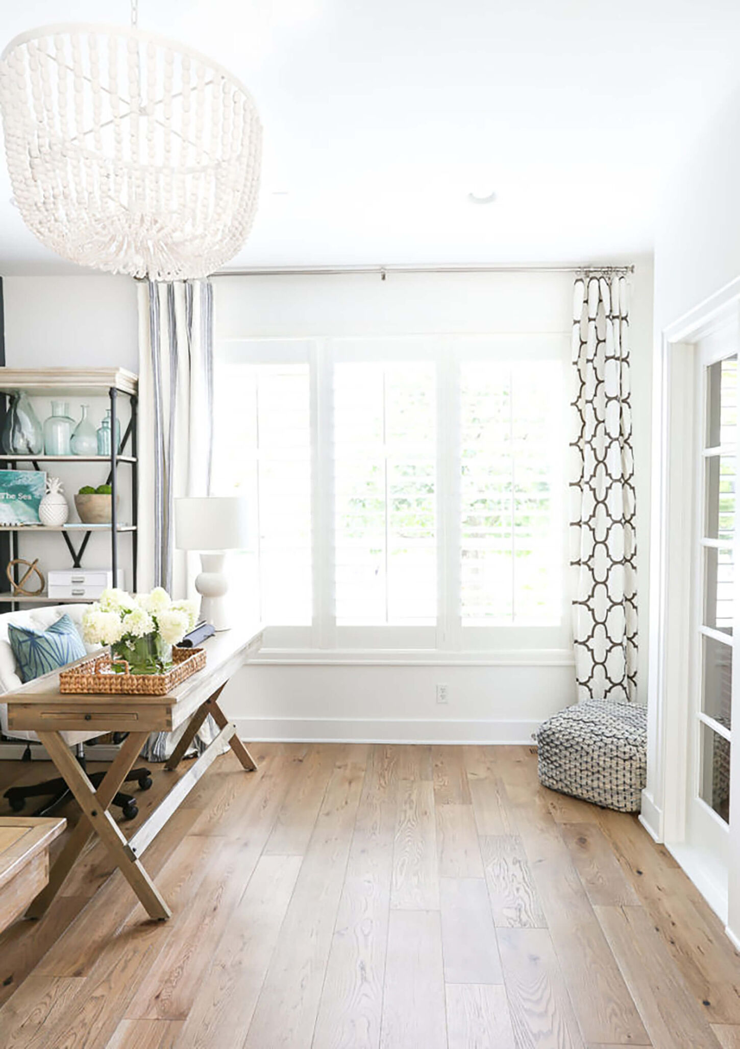 Bright office area with a desk, curtain, white light fixture, and bamboo wood floors.