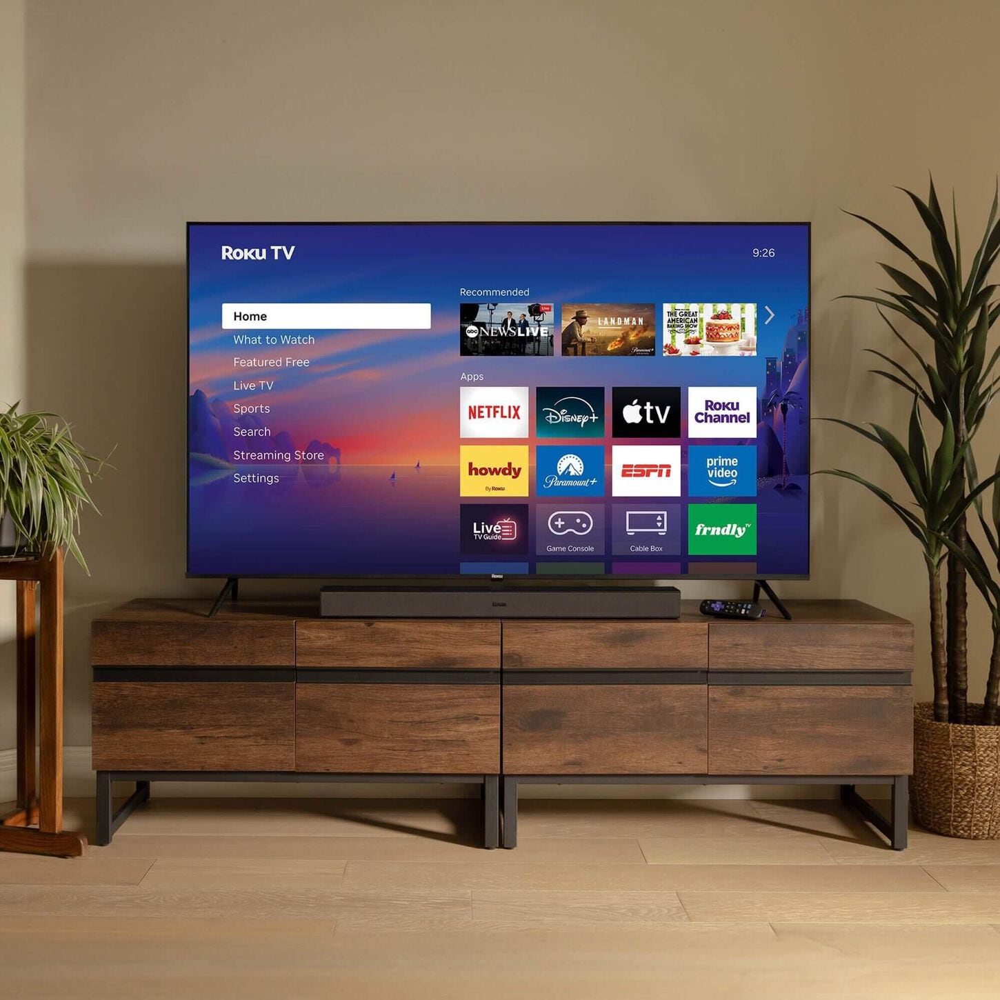 4K tv on a dark wood entertainment stand in a cozy room