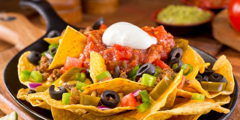 Plate of large batch of Nachos with all of the fixings.