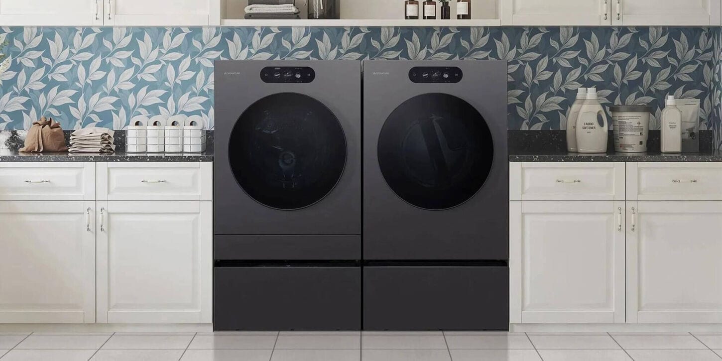 dark grey front load laundry pair in a room between white cabinets