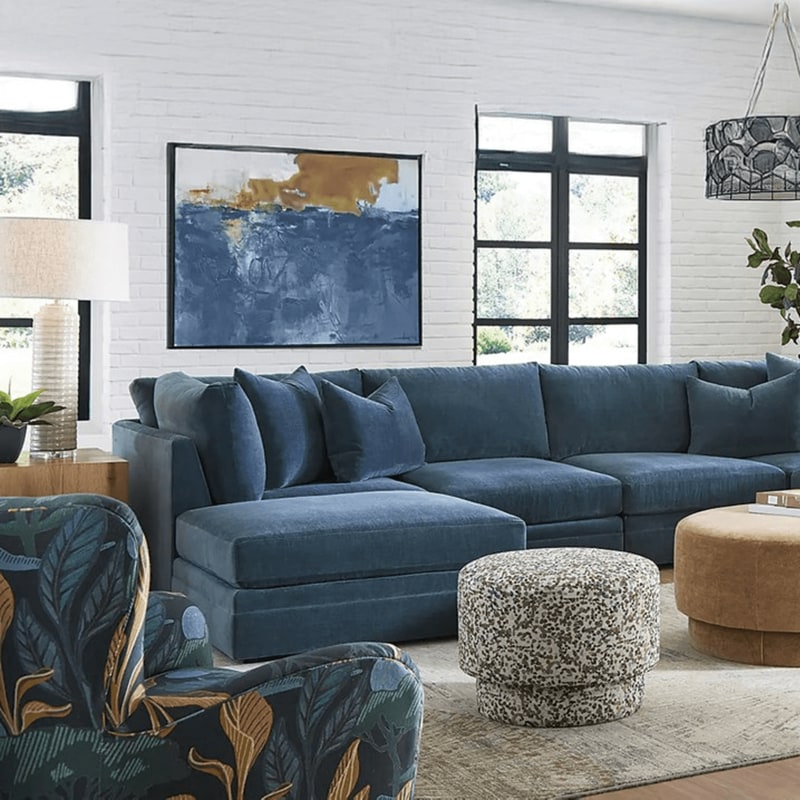 Blue upholstered sectional with accent chairs and ottomans