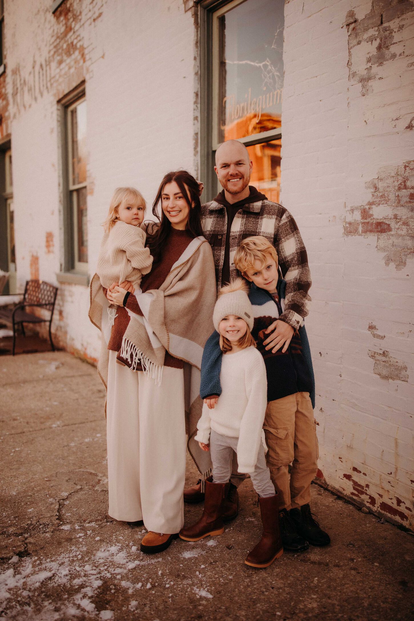 Megan and her husband and children posing for a family picture outside