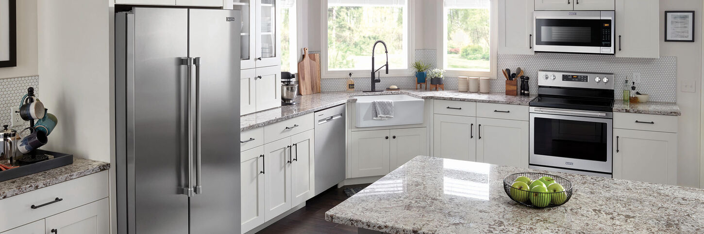 Maytag kitchen appliances in kitchen with stainless steel finishes and white cabinets