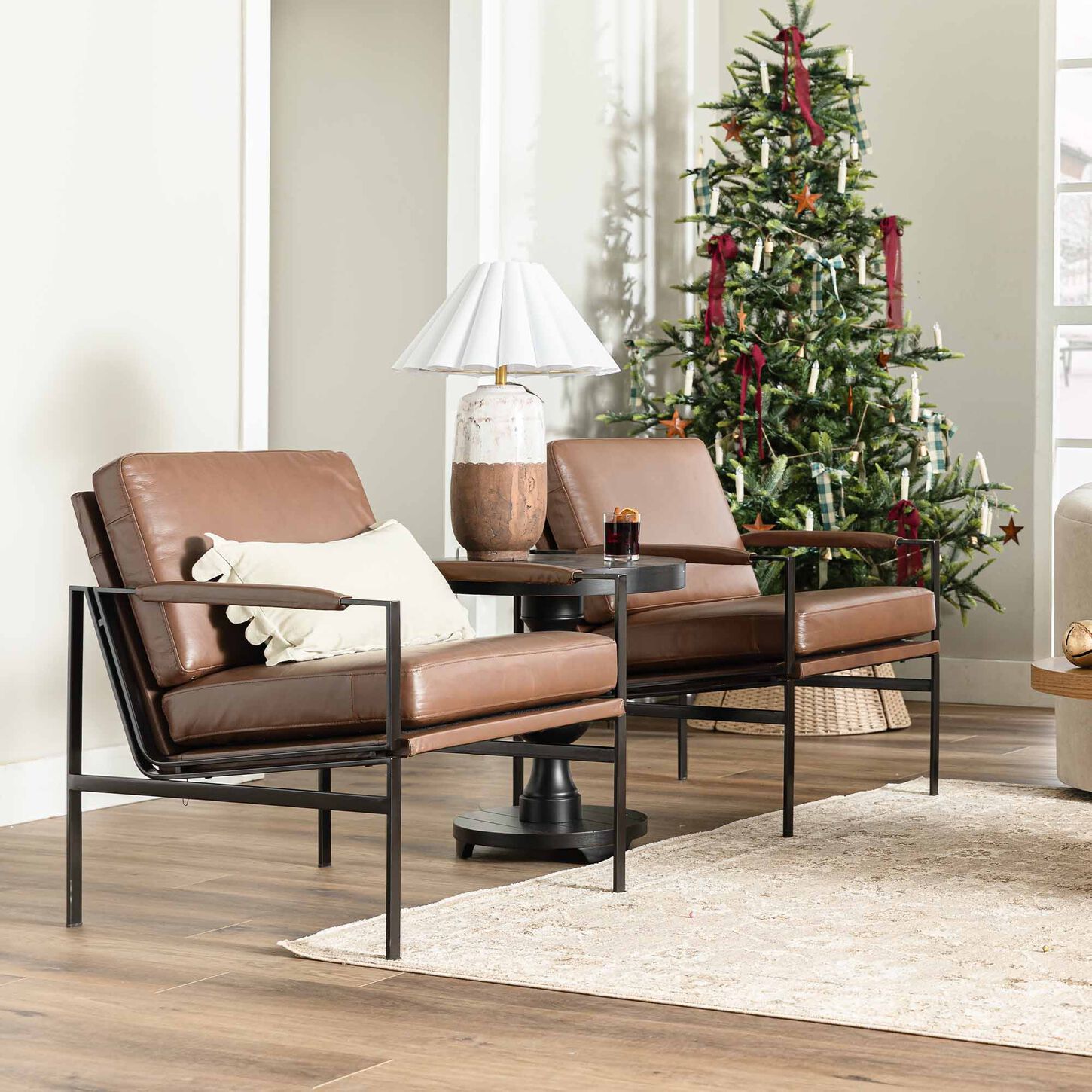 Brown leather accent chairs with Christmas tree in background