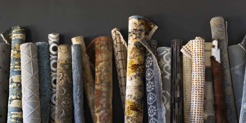Various area rugs rolled up showing wide range of selection at NFM