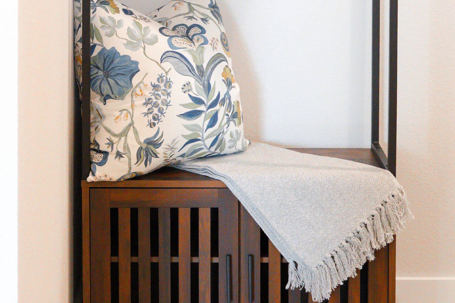 An entry way table with two plants and a circle mirror.