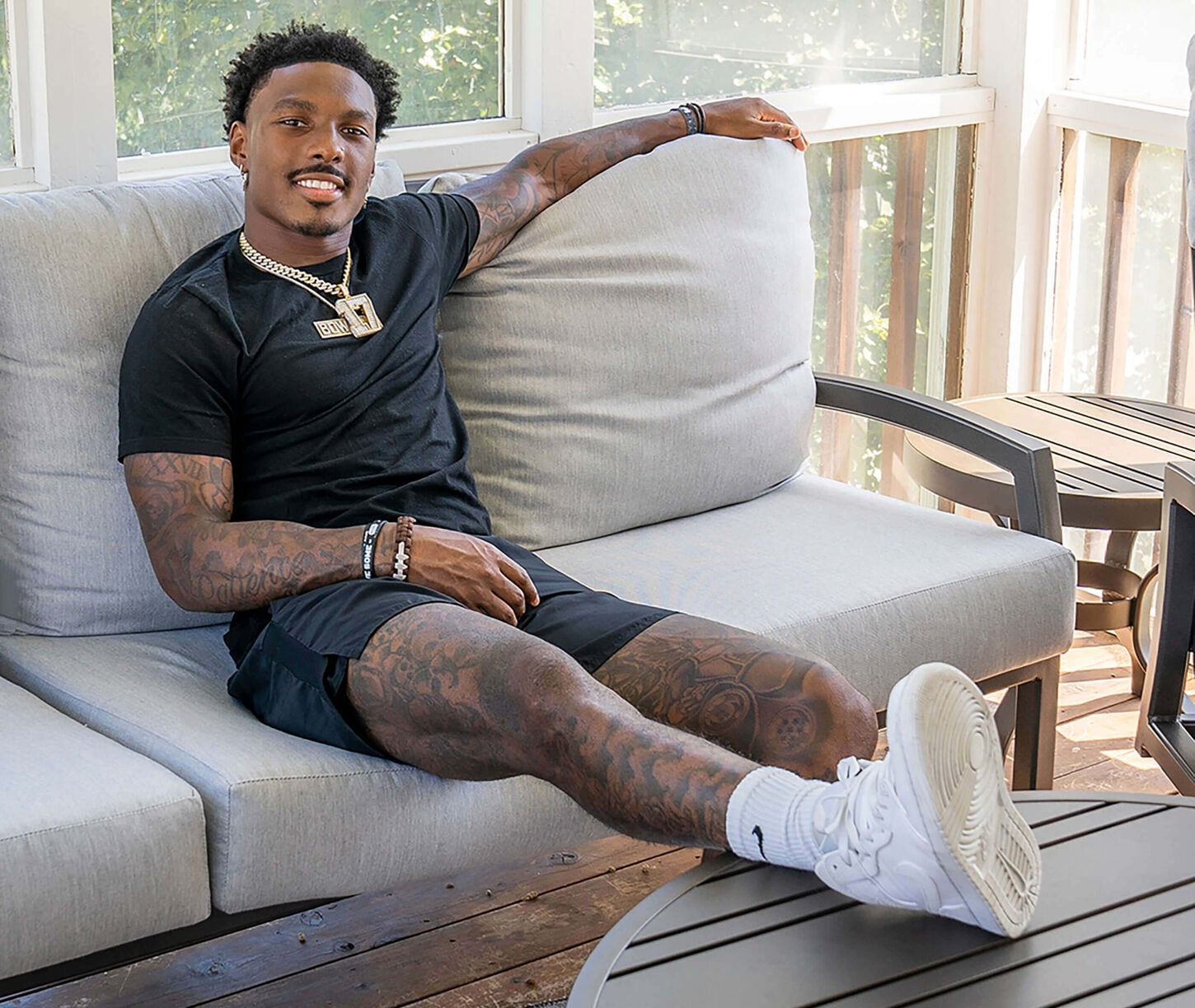 Mecole Hardman sitting on a white sofa with his feet kicked up