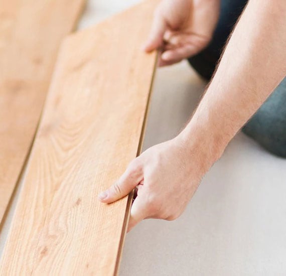 Contractor placing new flooring in customer's home.