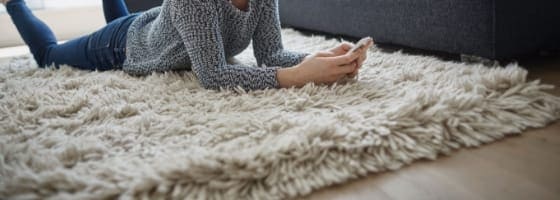 Woman laying on area rug on wood floors